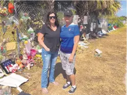  ?? ROBERT RAY/ASSOCIATED PRESS ?? Melissa Broccoli, left, and Christine Dunhill meet while waiting to pick up their children from Marjory Stoneman Douglas High School on Thursday.