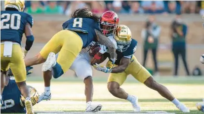  ?? MARC LEBRYK/AP ?? UNLV wide receiver Ricky White (11) takes a hard hit during the second half of a game against Notre Dame on Oct. 22.