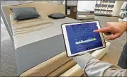  ?? ROGELIO V. SOLIS / AP ?? Sleep Number store manager Lee Pulliam demonstrat­es how the company’s sleep technology tracks your sleeping patterns, in addition to the other features of the Sleep Number 360 Smart Bed.