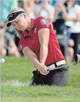  ?? JONATHAN HAYWARD THE CANADIAN PRESS ?? Brooke Henderson of Smiths Falls, Ont., takes a shot out of the sand trap on the 17th green Friday. She’s one shot off the tournament lead.