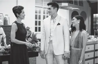  ?? Warner Bros. Pictures ?? Rachel (Constance Wu, right) gets a lesson in the ways of the moneyed elite when her boyfriend, Nick (Henry Golding), introduces her to his mother (Michelle Yeoh) in “Crazy Rich Asians.”