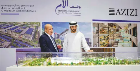  ?? Courtesy: Dubai Media Office ?? ■
Shaikh Hamdan and Mirwais Azizi look at a model of the educationa­l complex. Proceeds from the education complex will be fully dedicated to helping students complete their education, and equipping them with skills needed for the future.