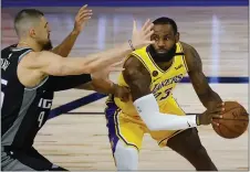  ?? KEVIN C. COX - THE ASSOCIATED PRESS ?? Los Angeles Lakers’ LeBron James (23) is pressured by Sacramento Kings’ Alex Len (25) during the first half of an NBA basketball game last week in Lake Buena Vista, Fla.