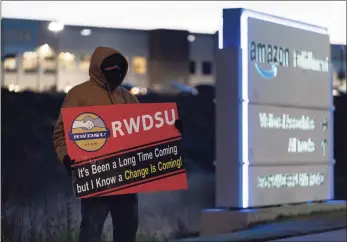  ?? Getty Images ?? A union rep holds a sign outside the Amazon fulfillmen­t warehouse at the center of a unionizati­on drive on Monday in Bessemer, Ala. Employees at the fulfillmen­t center are currently voting on whether to form a union, a decision that could have national repercussi­ons.