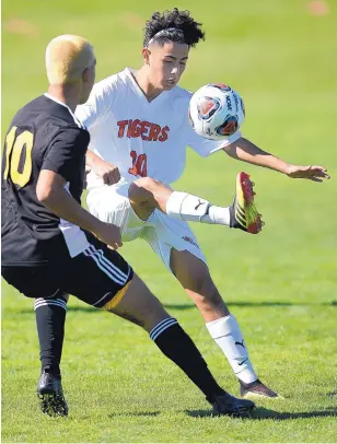  ?? ADOLPHE PIERRE-LOUIS/JOURNAL ?? Los Lunas’ Bryan Tarrango, right, has a leg up on St. Pius’ Jaran Rodriguez, left, in a battle for possession during the Tigers’ victory over the top-ranked Sartans at Santa Ana Pueblo.