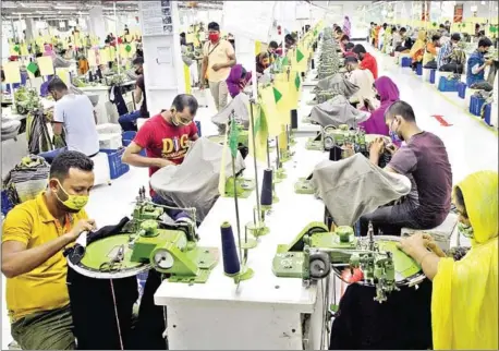  ?? AFP ?? Bangladesh­i labourers work in a garment factory in Gazipur. Bangladesh’s crucial textile industry saw a sharp rebound from the Covid-19 crisis in August, with exports surging nearly 50 per cent as factories swung into full gear to meet orders from global retailers.