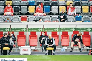  ??  ?? Keeping your distance
Uwe Rosler, head coach of Fortuna Dusseldorf, watches on as support staff and substitute­s socially distance while wearing face masks