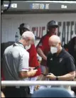  ?? Associated Press ?? DELAY — North Carolina State personnel chat in the dugout during a delay due to COVID-19 safety protocols before their game against Vanderbilt in the College World Series Friday at TD Ameritrade Park in Omaha, Neb.