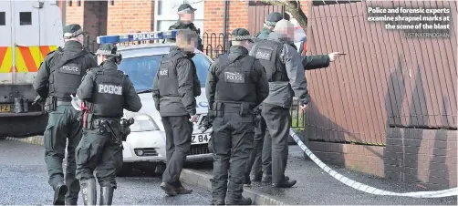  ?? JUSTIN KERNOGHAN ?? Police and forensic experts examine shrapnel marks at
the scene of the blast