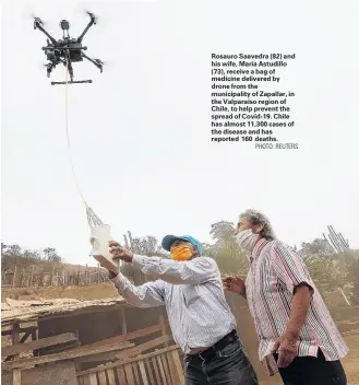  ?? PHOTO: REUTERS ?? Rosauro Saavedra (82) and his wife, Maria Astudillo (73), receive a bag of medicine delivered by drone from the municipali­ty of Zapallar, in the Valparaiso region of Chile, to help prevent the spread of Covid19. Chile has almost 11,300 cases of the disease and has reported 160 deaths.