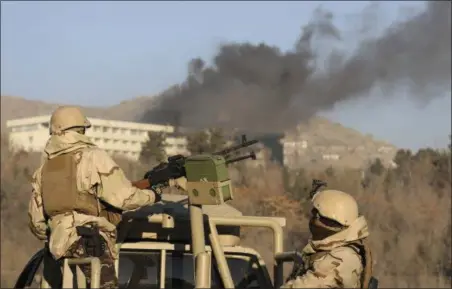  ?? RAHMAT GUL — THE ASSOCIATED PRESS ?? Afghan security personnel stand guard as smoke rises from the Interconti­nental Hotel after an attack in Kabul, Afghanista­n, Sunday. Gunmen stormed the hotel in the Afghan capital on Saturday evening, triggering a shootout with security forces,...