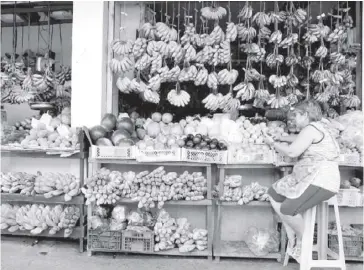  ?? ABS-CBN NEWS ?? A vendor surfs the internet on her mobile phone as she waits for customers at a fruit stall in Manila.