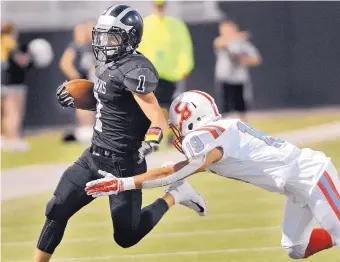  ?? JIM THOMPSON/JOURNAL ?? Volcano Vista’s Blaine Grant (1) tries to evade Sandia’s Gestic Marquez has he runs down field Thursday night at Community Stadium.