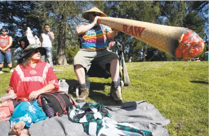  ?? Paul Chinn / The Chronicle ?? Above: Bear Waite, next to wife Michelle, inflates a very large replica of a joint. Left: Old-fashioned doobies are sold at the 4/20 celebratio­n on Hippie Hill.