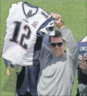  ?? AP PHOTO ?? New England Patriots quarterbac­k Tom Brady displays his recovered jersey, which was stolen from the locker room after the Patriots’ February Super Bowl victory over the Atlanta Falcons in Houston, during pre-game ceremonies before a baseball game...