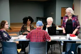  ?? (The Sentinel-Record/Lance Brownfield) ?? Local authors gather for a brunch at the Garland County Library on Saturday. Working in a group on a creative exercise, Phyllis Hodges, second from left, works with her husband, Byron Hodges, seated next to her, Ashlee Nix-Linsley, to her right, and Gary Strakshus across the table, while Jenny Carlisle, the presenter at the event, assists them.