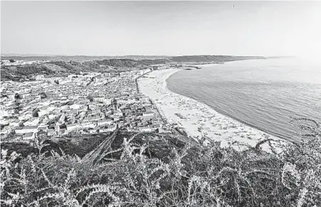  ?? DOMINIC ARIZONA BONUCCELLI/RICK STEVES’ EUROPE ?? Nazaré hugs its wide beach on the Atlantic. The fishing-town-turned-tourist-retreat is a place to relax in the sun.