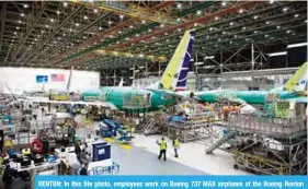  ?? —AFP ?? RENTON: In this file photo, employees work on Boeing 737 MAX airplanes at the Boeing Renton Factory in Renton, Washington.