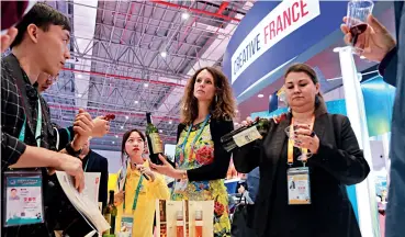  ??  ?? Le 7 novembre 2018, des visiteurs dégustent du vin français à la CIIE.