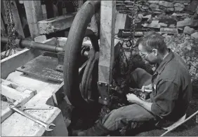  ?? SEAN D. ELLIOT/THE DAY ?? Tom Miesen and Matt Holcomb, not pictured, of Collins & Jewell install the pitman arm on the flywheel at the Ledyard Historic Up-Down Sawmill last Thursday.