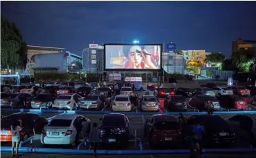  ??  ?? Night under the stars: Movie-goers enjoying the latest movie while staying cool in their cars at the drive-in theatre in Bangkok. — reuters