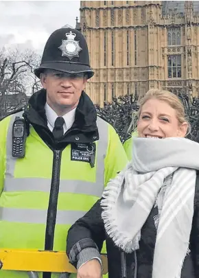  ?? Pictures: AP/PA. ?? Above: Staci Martin posing for a photo next to PC Keith Palmer outside the Houses of Parliament. Right: police officers bow their heads as flowers are left in central London.