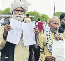  ?? MUJEEB FARUQUI/HT PHOTO ?? Farmers show the applicatio­ns that they handed over to Madhya Pradesh chief minister Shivraj Singh Chouhan in Bhopal on Sunday.