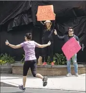  ?? Mel Melcon Los Angeles Times ?? JULIANN and Butch Hartman hold signs of support last month in Calabasas, where they’ve lived 20 years.