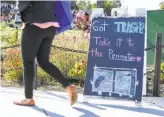  ?? Amy Osborne / Special to The Chronicle ?? A sign instructs visitors to bring their trash to collection areas located around the perimeter of Dolores Park, though many ignore it.