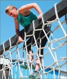  ?? Photo by Erica Moser ?? After getting to the top of the cargo net, Deb Westgate-Silva assesses how to get down the other side. She said of the various obstacles at Fore Court, “The higher they are, the more hesitant I am, but I'm trying to get over it.”