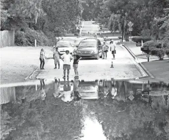  ?? BRAD MCCLENNY/USA TODAY NETWORK ?? The single exit road from the Robin Lane neighborho­od is flooded Thursday in Gainesvill­e, Fla., after heavy rain from Tropical Storm Elsa. It’s heading northeast.