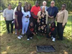  ??  ?? Family members of Alexander McClay Williams gather at his grave site Saturday. The family finally was able to put a proper grave marker on the site.