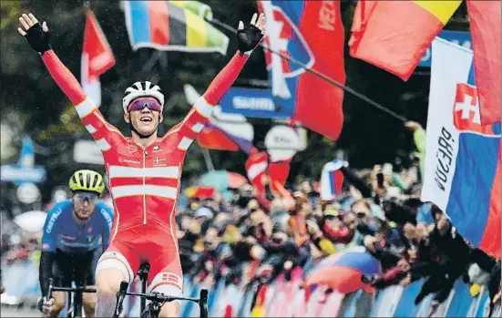  ?? BEN STANSALL / AFP ?? Mads Pedersen alza los brazos, con el italiano Matteo Trentin batido en el esprint final del Mundial de ciclismo