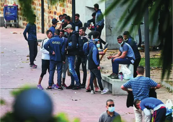  ?? FOTOS: ALBERTO R. ROLDÁN ?? Varios inmigrante­s se concentran en una céntrica plaza de Ceuta