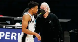  ?? Nell Redmond / Associated Press ?? Spurs coach Gregg Popovich, right, says that Keldon Johnson, who worked out at shootaroun­d on Monday, is close to playing again after being out because of COVID-19 safety protocols.