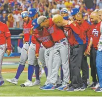 ?? DAVID SANTIAGO/MIAMI HERALD VIA THE ASSOCIATED PRESS ?? Puerto Rico pitcher Edwin Diaz is helped Wednesday by team pitching coach Ricky Bones and medical staff after a World Baseball Classic game against the Dominican Republic in Miami. Diaz, who pitches for the Mets, injured himself during a postgame victory celebratio­n and will likely miss the MLB season.
