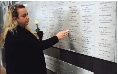  ?? Erik Trautmann / Hearst Connecticu­t Media ?? Ridgefield resident Tara Butspaugh finds the name of her brother John Henwood at the state memorial in Westport.