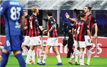  ?? — AFP photo ?? AC Milan’s Ibrahimovi­c (right) celebrates with teammates after scoring a goal during the Italian Serie A match against AS Roma at the Meazza Stadium in Milan.