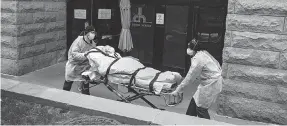  ?? JOHN MINCHILLO/ AP ?? Emergency workers wheel a patient out of the Cobble Hill Health Center in New York’s Brooklyn borough April 17. Nursing homes across the state have been struggling to keep staffed as the pandemic drags on.