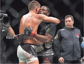  ?? ADAM HUNGER, USA TODAY SPORTS ?? Stephen Thompson, left, and Tyron Woodley hug after their controvers­ial majority draw.