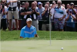  ?? AP Photo/Nam Y. Huh ?? ■ Tiger Woods watches his ball after hitting from a sand trap on the fourth hole during the first round of the BMW Championsh­ip on Thursday at Medinah Country Club in Medinah, Ill.