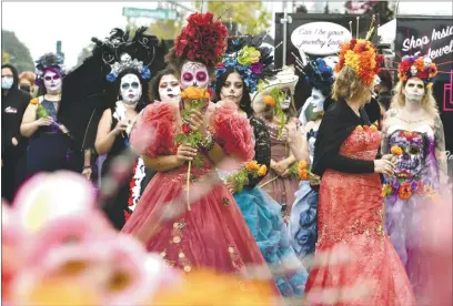  ?? PHOTOS BY CHRIS RILEY — TIMES-HERALD ?? Jasmine Robinson of Fairfield smells marigolds as she waits with other Catrinas to place the flowers on the ofrenda during the Day of the Dead celebratio­n in downtown Vallejo on Saturday.