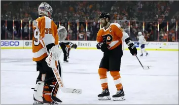  ?? MATT SLOCUM - THE ASSOCIATED PRESS ?? Flyers captain Claude Giroux, right, and goalie Carter Hart celebrate after a goal by Giroux against Buffalo March 7. The Flyers did a lot of celebratin­g on a hot streak before the NHL paused due to the coronaviru­s pandemic, and coach Alain Vigneault is confident his team will be ready when it ends.