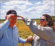  ?? REUTERS ?? Australia’s richest person and mining magnate, Gina Rinehart (right), adjusts a cap on the head of Martin Ferguson, the country’s minister for resources, energy and tourism, during a visit to the Alpha Coal project test pit in the Galilee Basin, about...