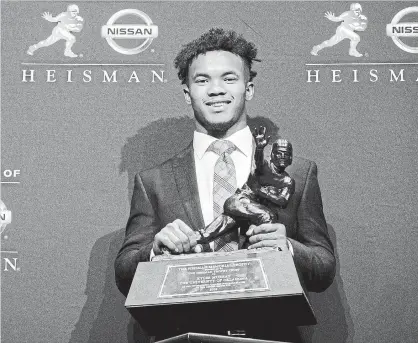  ?? CRAIG RUTTLE THE ASSOCIATED PRESS ?? Oklahoma quarterbac­k Kyler Murray, pictured here with the Heisman Trophy, was also drafted by baseball’s Oakland A’s in June.