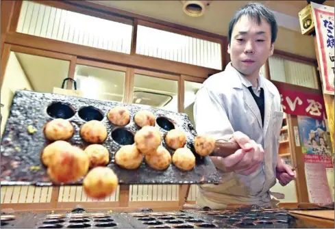  ?? THE JAPAN NEWS ?? Umaiya owner Taizo Kita cooks takoyaki octopus balls.
