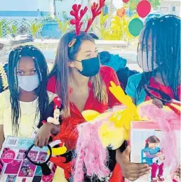  ?? CHRISTINA ARZEE ?? Songwriter and philanthro­pist Ali Tamposi visits with children at the First Haitian Baptist Church’s children’s holiday gift-giving event in Belle Glade.