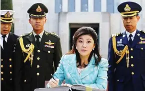  ??  ?? One year on: Yingluck signing the visitors’ book at the Australian War Memorial in Canberra during her visit in this file photo. — AP