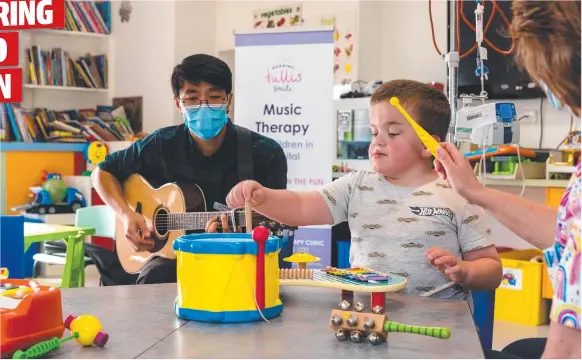  ?? ?? Chris Yuen, a registered music therapist, with a young Geelong hospital patient. Picture: Supplied by Barwon Health Foundation