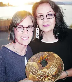  ??  ?? Northwest Ceramics Foundation awardees Jackie Frioud and Judy Chartrand display an auction item made and donated by Jean Fahrni, 99.